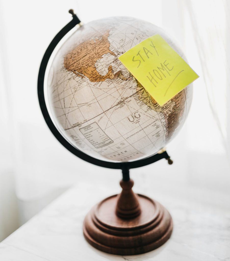 Globe with yellow sticky note "stay home"