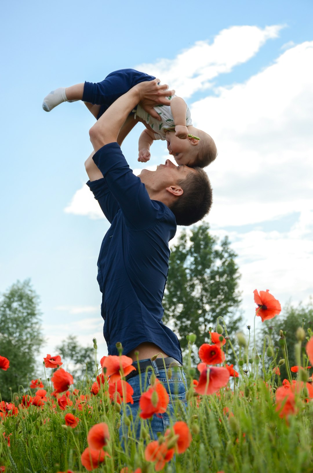 Photo by Natasha Ivanchikhina man in blue long sleeve shirt carrying baby in white onesie