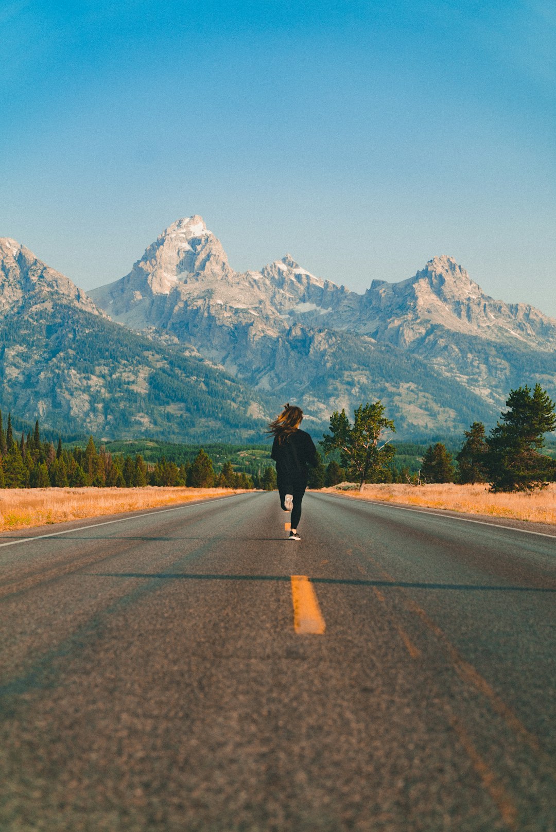 Photo by Josh Gordon woman walking on road during daytime
